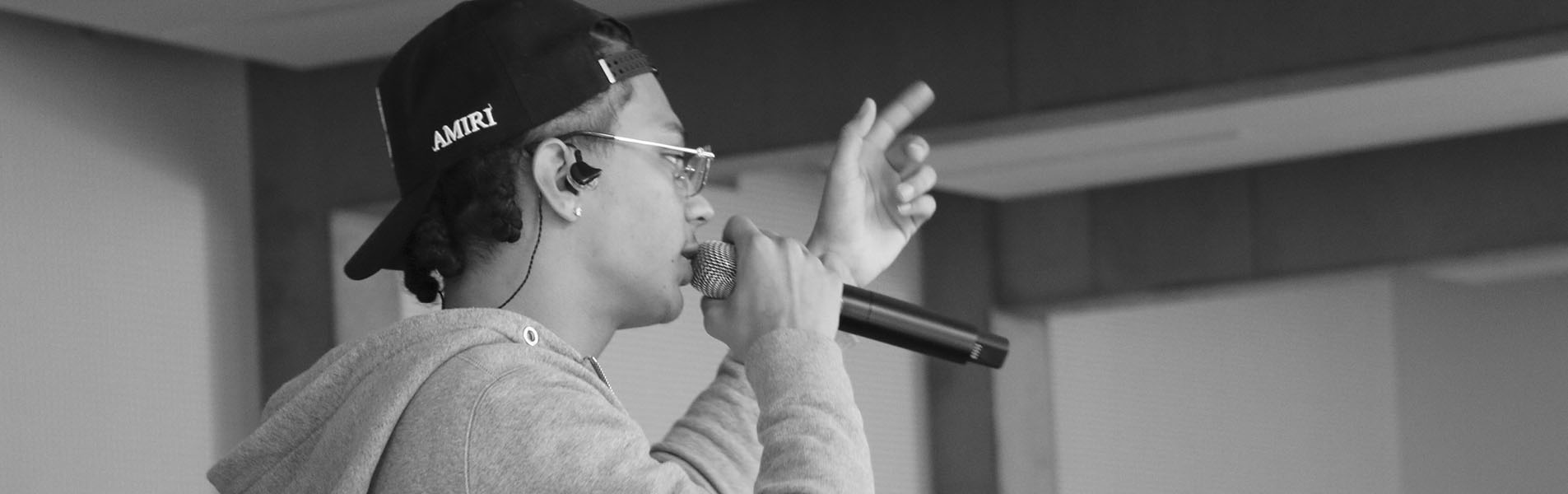 Le chanteur Fave tient un micro et chante pour les étudiants.