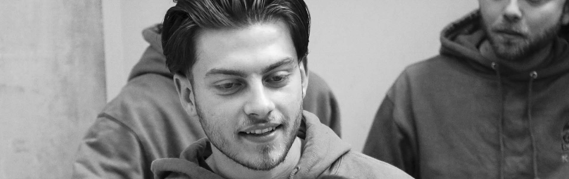 Étudiant qui sourit et deux étudiants en fond